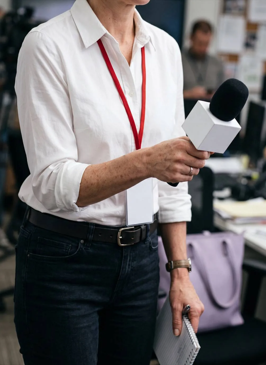 Person holding a microphone at an event.