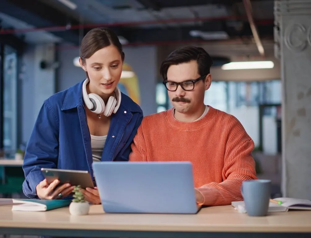 Two people reviewing a laptop together.