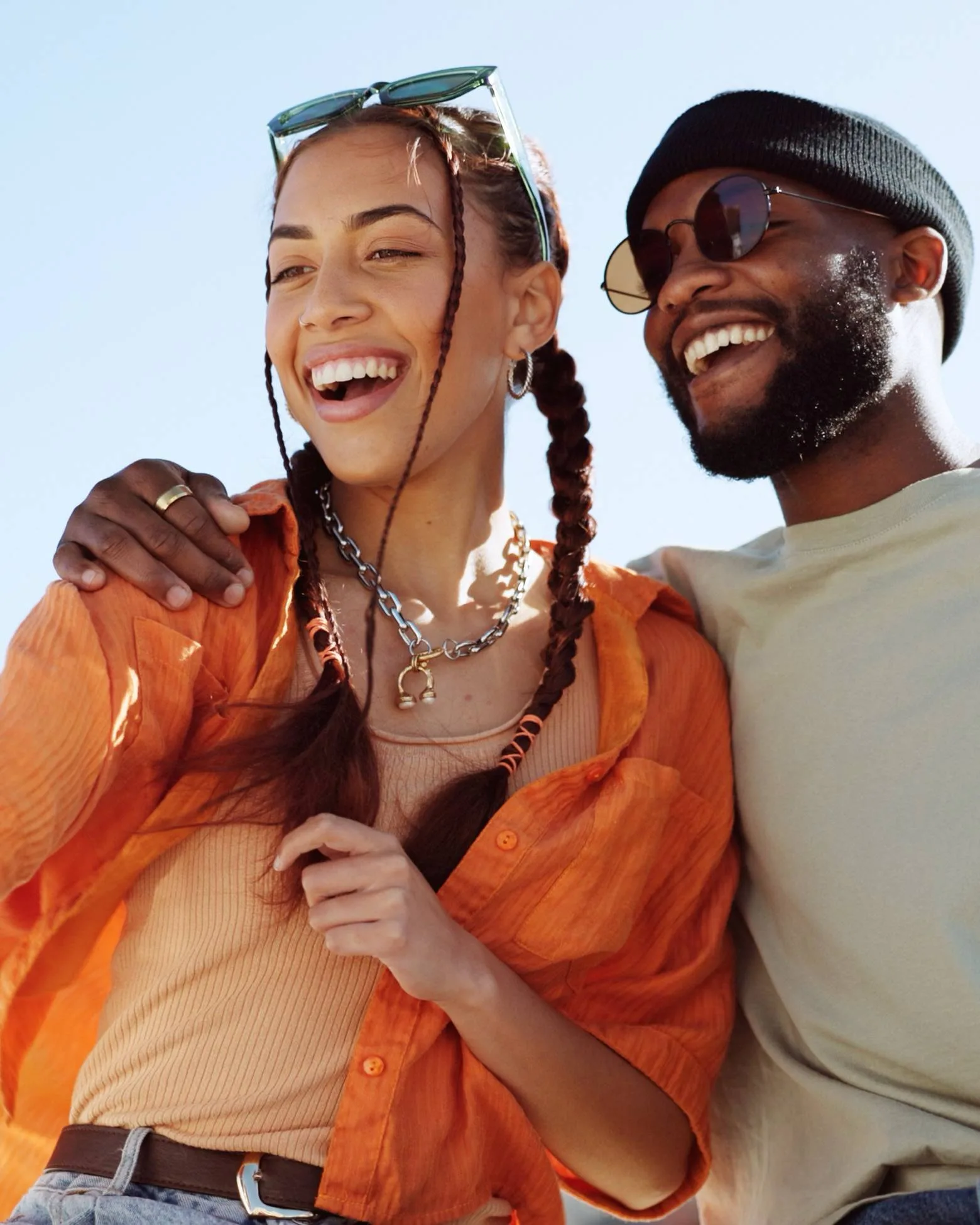 Two people smiling together outdoors.