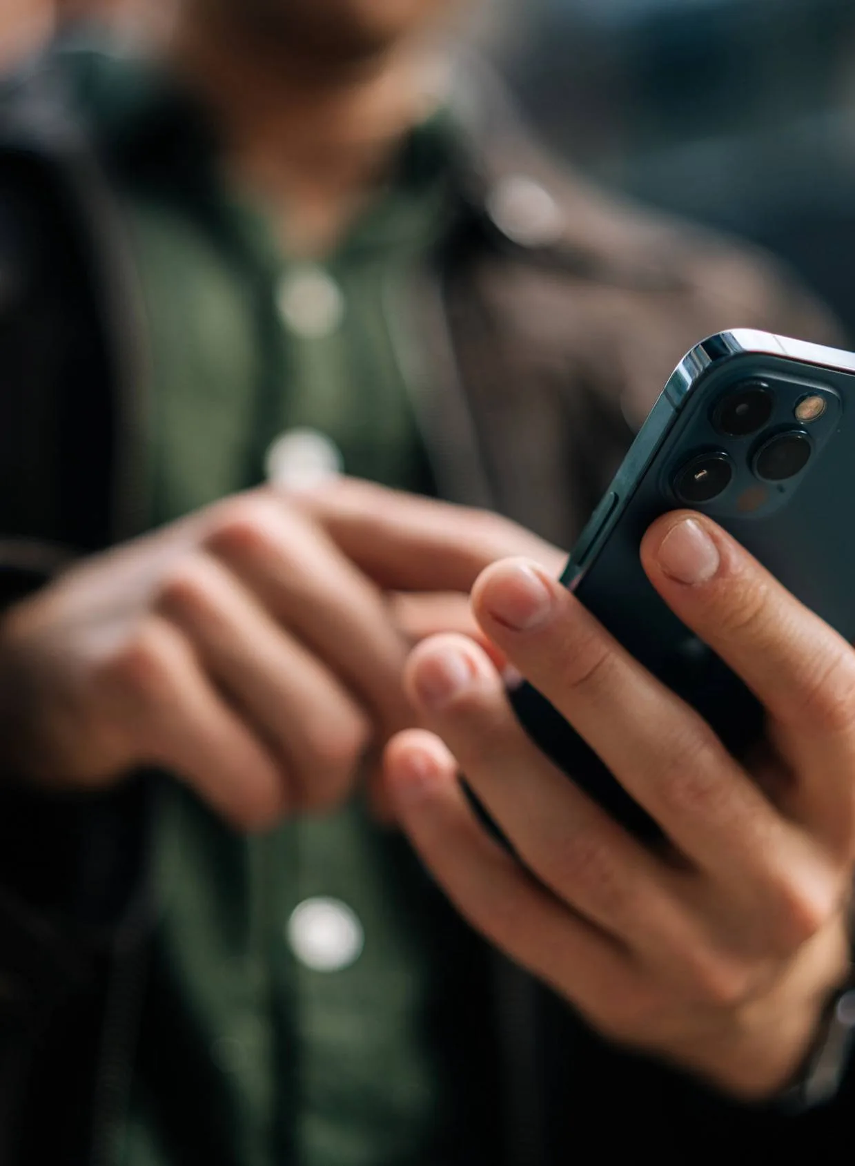 Close-up of a person typing on a smartphone.
